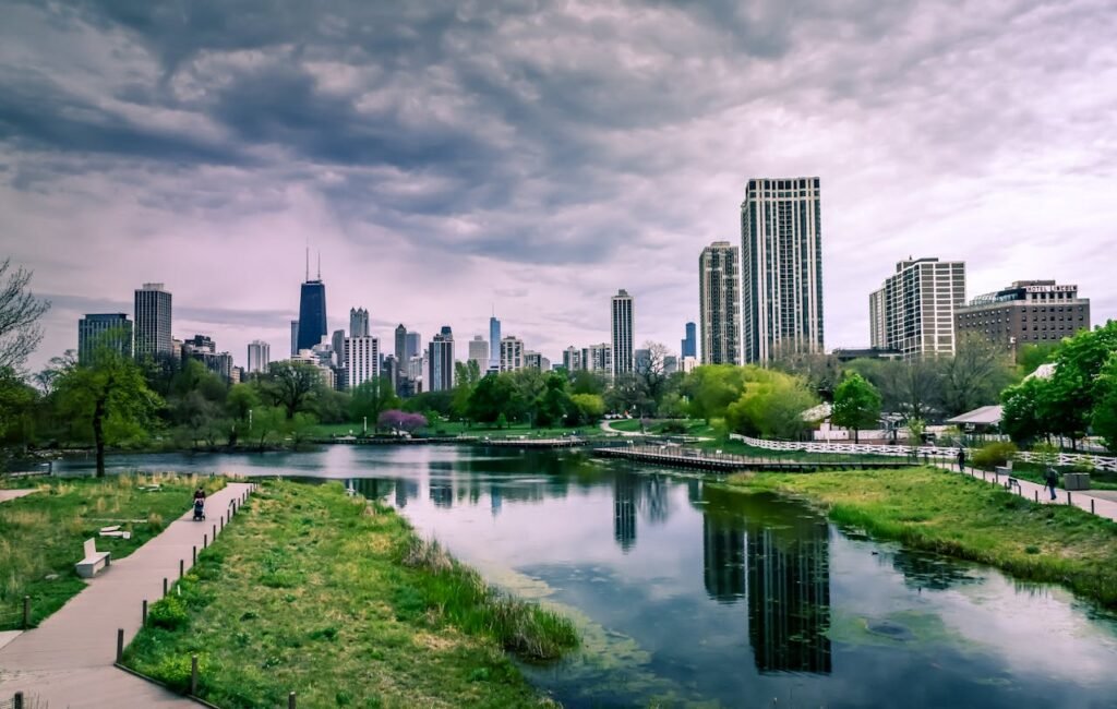 River Near City Buildings Under Cloudy Sky