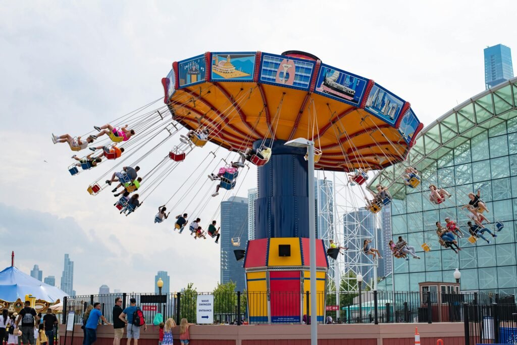 Swing carousel ride at Navy Pier with people enjoying the view of Chicago skyline.